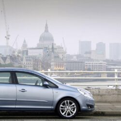 Vauxhall Corsa Side Pose In Blue Near Buildings Wallpapers