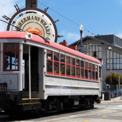 a cable car travels past the famous fisherman’s wharf district of