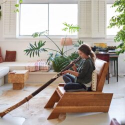 Hippy Woman Playing Didgeridoo At Home