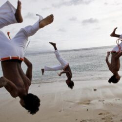 A group of men practice capoeira on the beach in Dili wallpapers